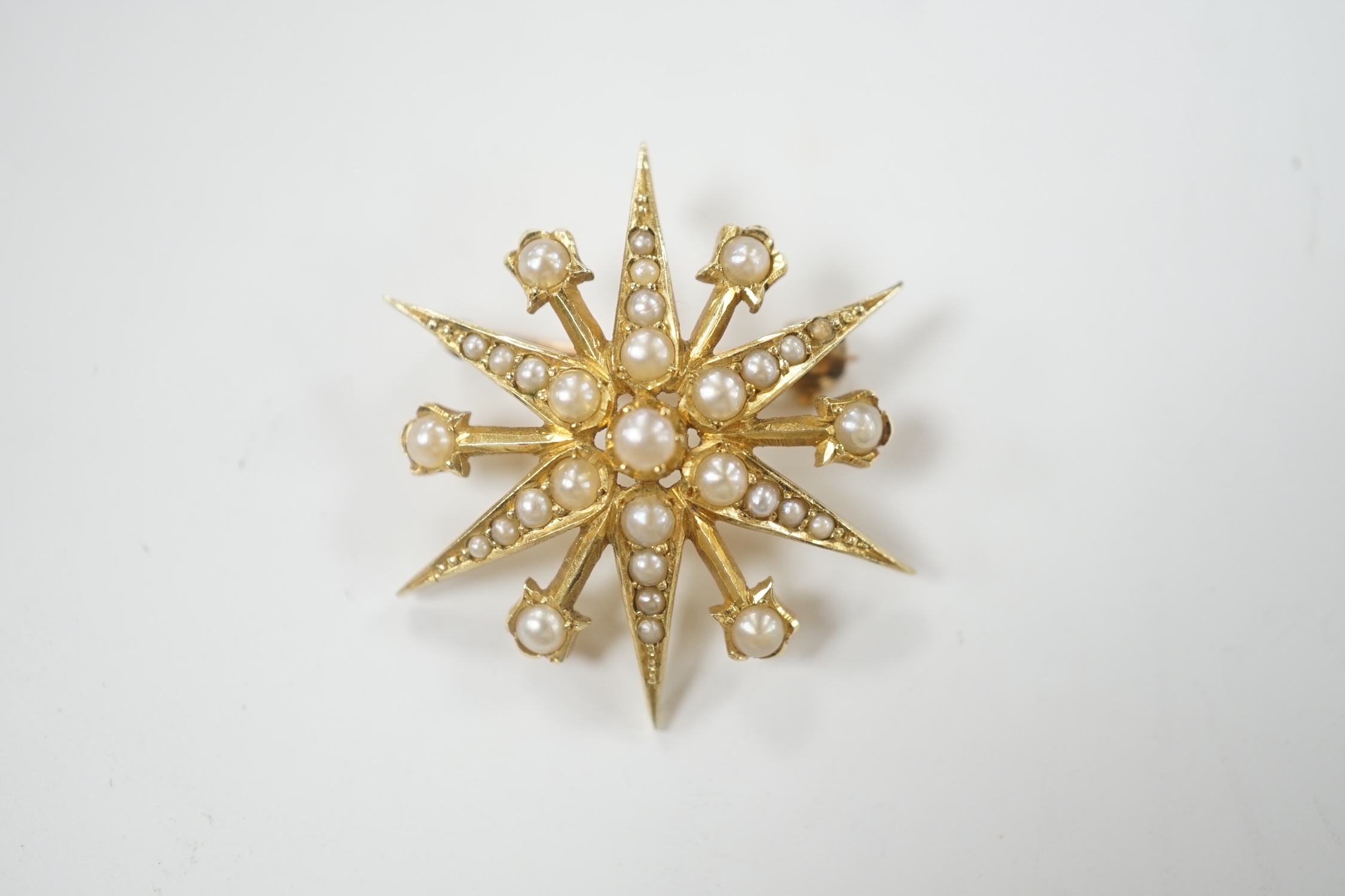 An Edwardian 15ct and split pearl cluster set starburst brooch, 29mm, gross weight 5.5 grams.